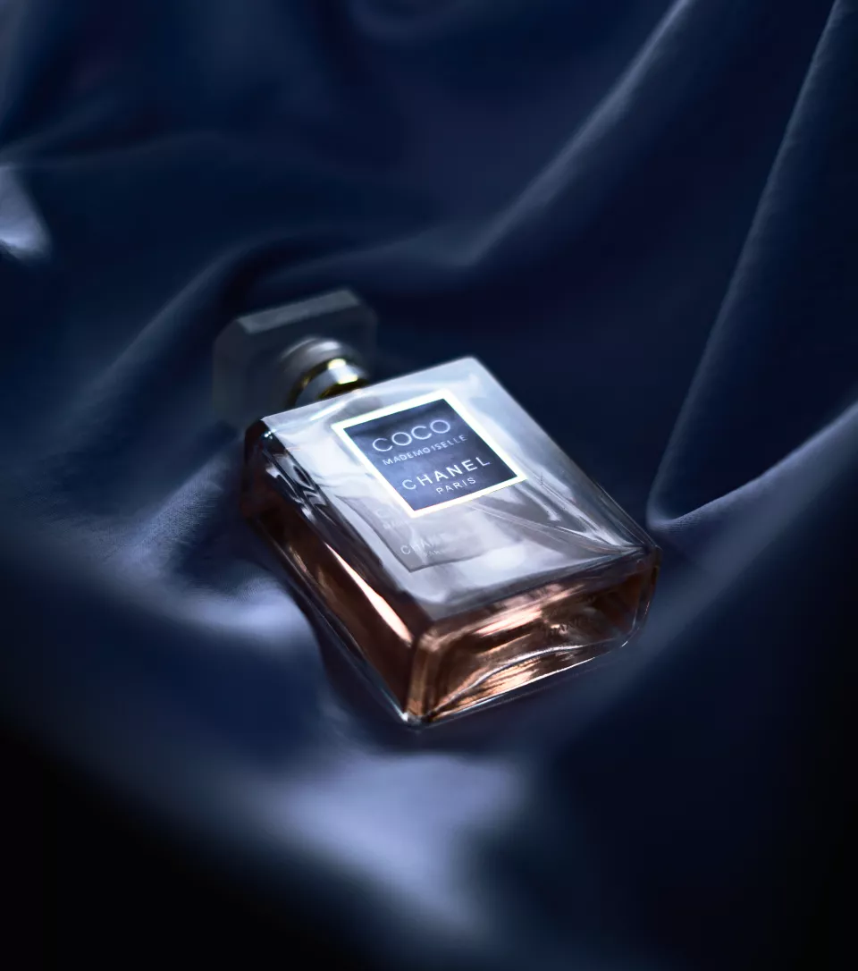 This shot feels very romantic and soft. By nestling the bottle in folded silk or satin, you’ve created a sense of intimacy—like a perfume sitting on a bedside table.